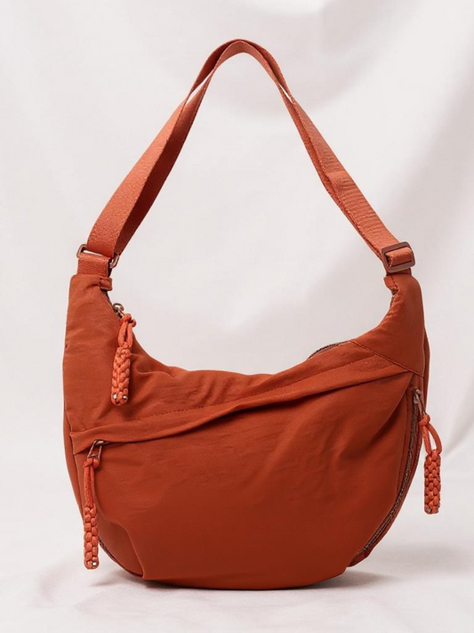 Bolso bandolera marrón de tela con asa ajustable y cierre con cordón