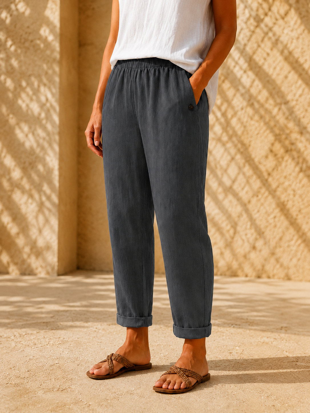 Pantalón efecto lino gris con cintura elástica y puño en el bajo, con detalle de botón.