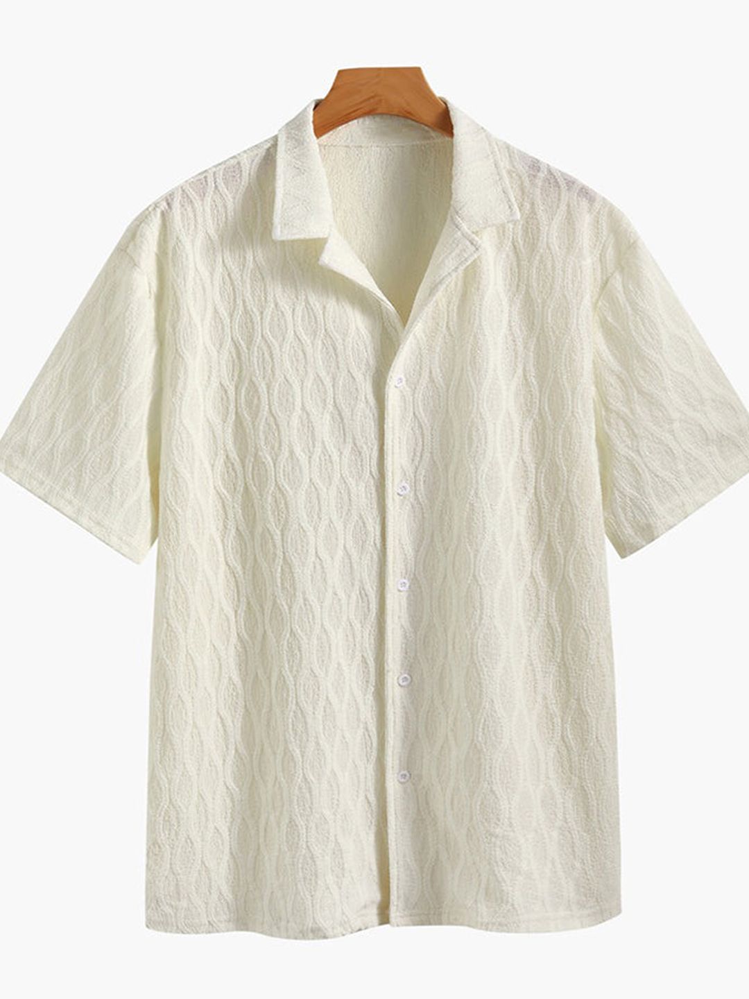 Camisa de manga corta crema con estampado texturizado, cuello camisero y botones.
